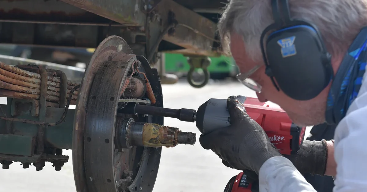 mechanic inspecting semi-trailer brake drum system close-up
